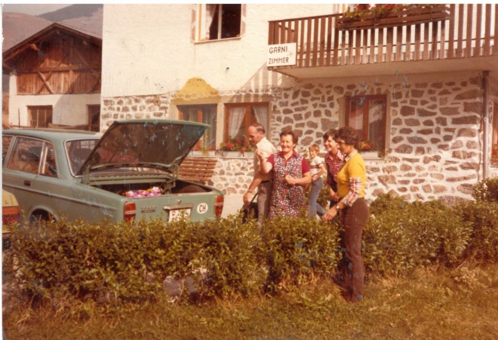 Gastfreundschaft und Gastlichkeit: Foto aus den 1970er Jahren, einer Privatzimmervermieterin in Laatsch (Mals), die gerade Gäste empfängt.